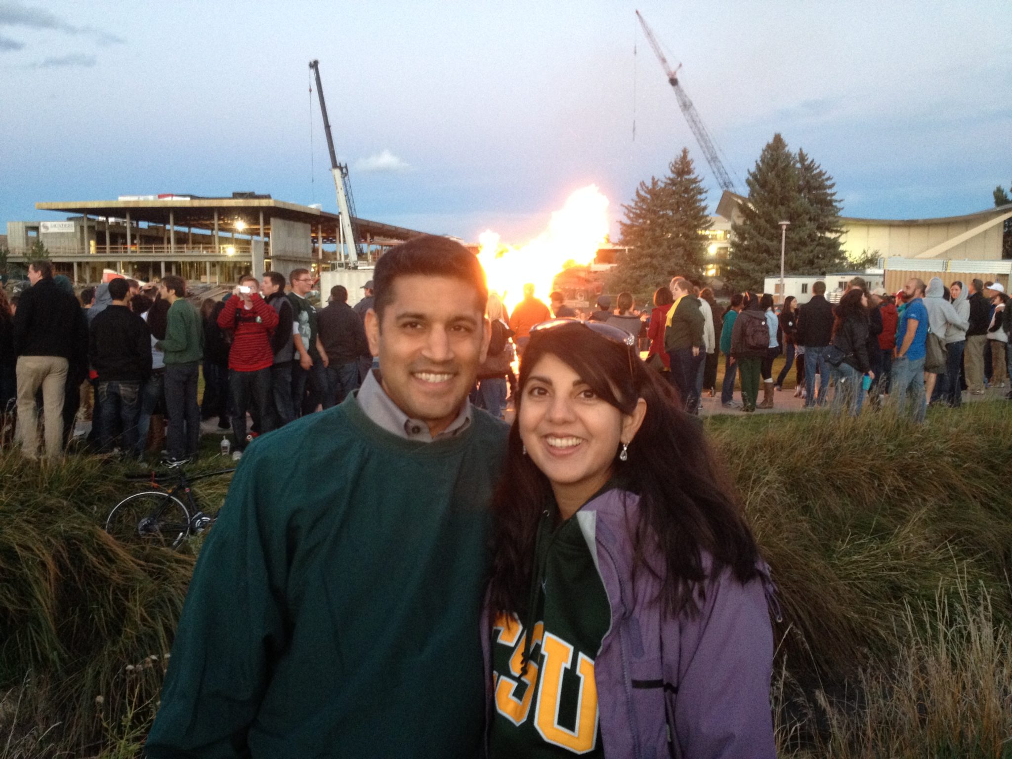 Shah and his wife during Homecoming and Family Weekend with bonfire and the Lory Student Cetner in the background
