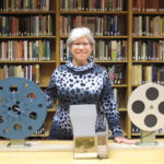 Lynn Smith in library with film reels