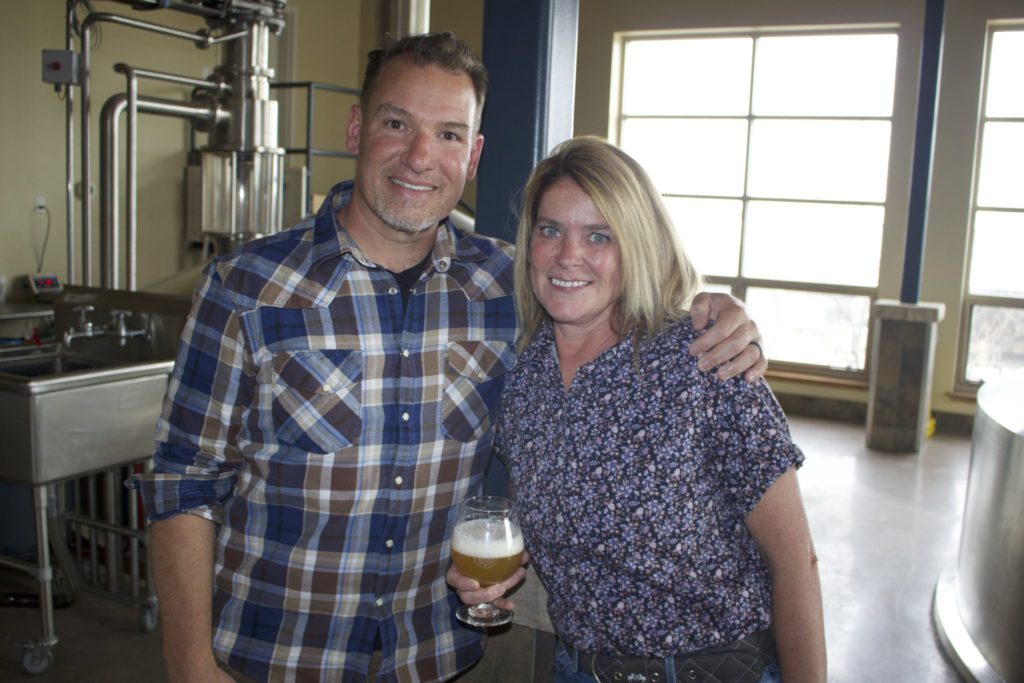 Brendan and Katie McGivney standing in the brewing room of Odell Brewing Co. 