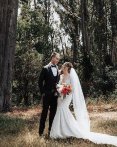 Lauren Sandell in wedding dress with her husband