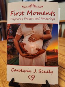 First Moments book cover on a stand, by Carolynn J. Scully