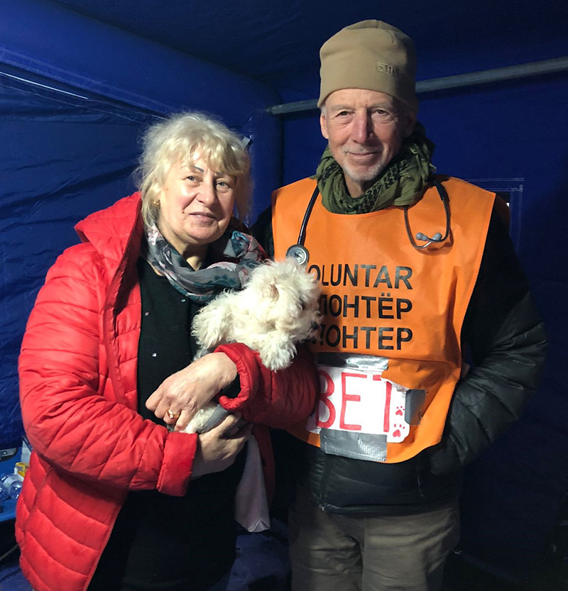A Ukrainian refugee and her dog stand with Dr. Jon Geller in the vet check station at the Ukraine-Romania border in March 2022.