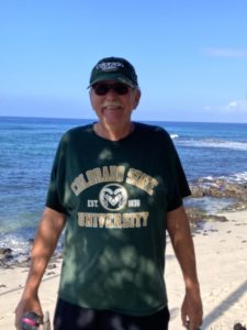 Man in CSU t-shirt on a beach