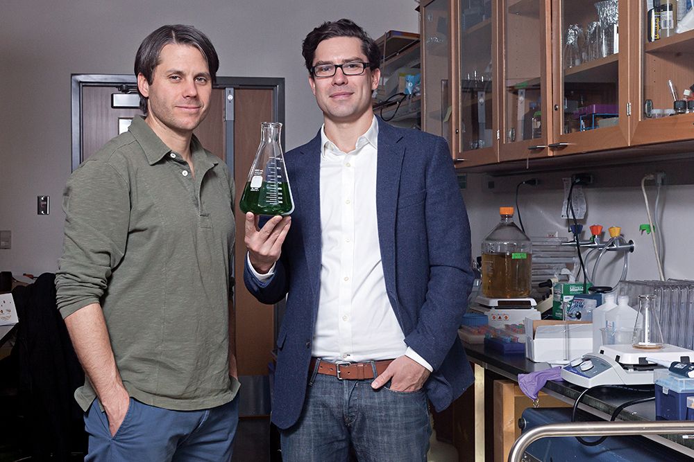 Steve Albers and Scott Fulbright holding a beaker of algae ink. 