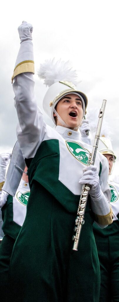 Isabella Wells holding a flute and performing with the CSU Marching Band 