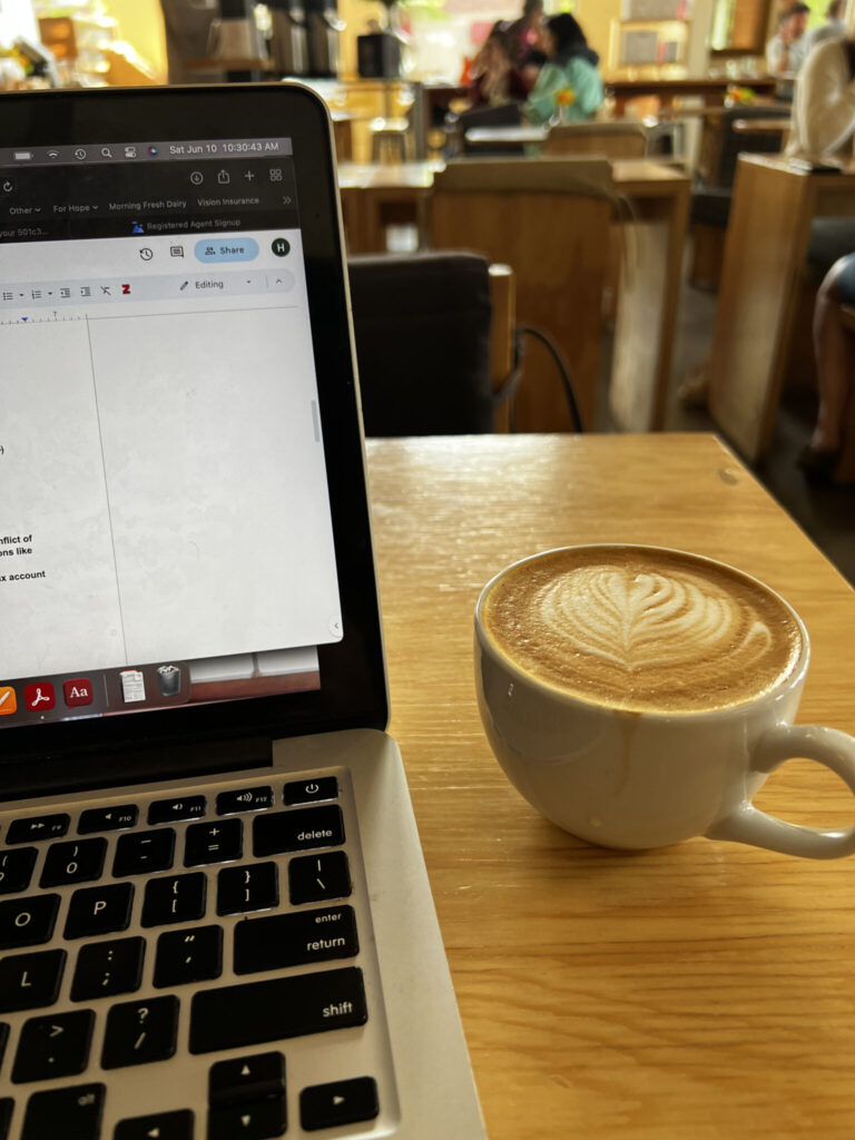 An open laptop beside a cup of coffee. 