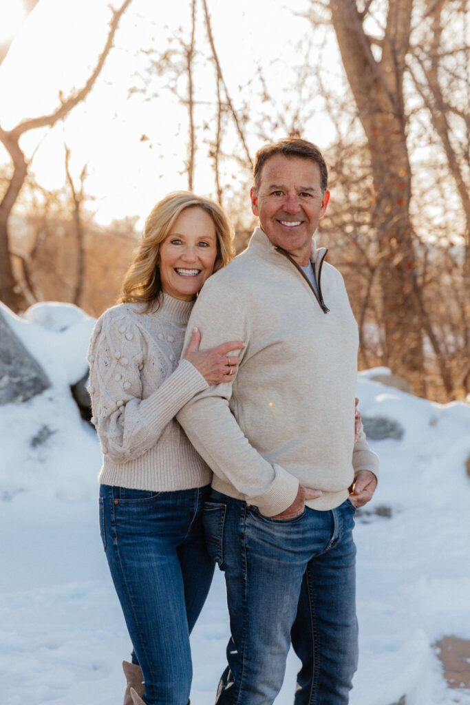 Kathy and David Burks wearing white sweaters in a snowy, wintry setting. 